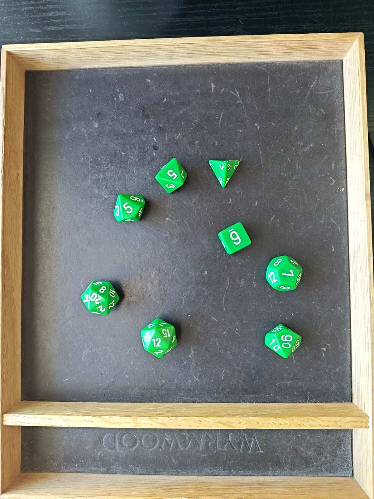 Ideal overhead framing — a full seven-die set spread across a Wyrmwood tray, shot straight down with even margins on all sides.